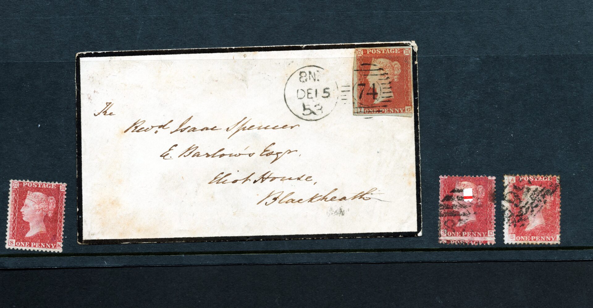 A selection of penny red stamps alongside a mourning letter which has a black border.