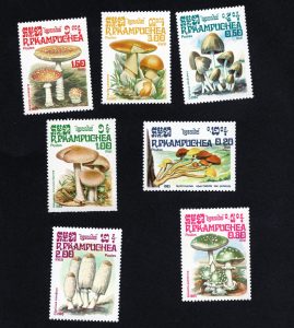 A set of seven 1985 Cambodian postage stamps featuring colourful illustrations of different mushroom species, each labeled with the Latin name and Riel value.